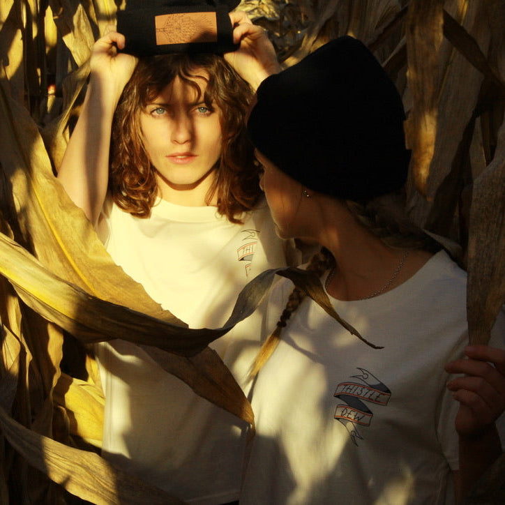 Two people in a cornfield with sunlight filtering through the leaves.